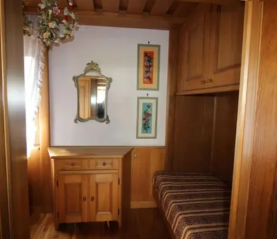 a small room with a bed and a mirror at Appartamento Croda in Cortina dʼAmpezzo