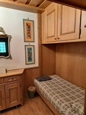 a bedroom with a bed and a sink and cabinets at Appartamento Croda in Cortina dʼAmpezzo