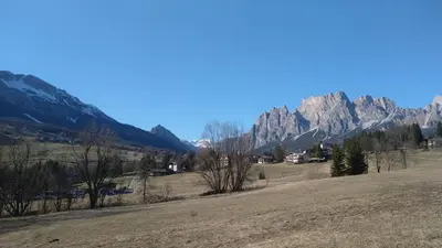 a view of a field with mountains in the background at Appartamento Croda in Cortina dʼAmpezzo