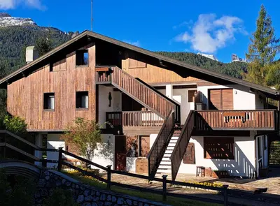a large wooden house with stairs on it at Appartamento Croda in Cortina dʼAmpezzo