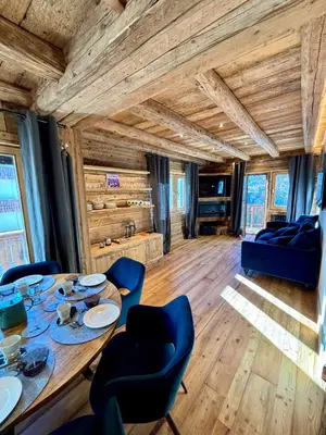 a dining room with a table and blue chairs at Luxury Central Apartment Cortina D'Ampezzo in Cortina dʼAmpezzo