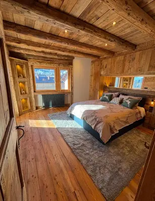 a bedroom with a bed in a room with wooden walls at Luxury Central Apartment Cortina D'Ampezzo in Cortina dʼAmpezzo