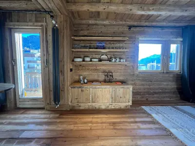 a kitchen with wooden walls and a sink and two windows at Luxury Central Apartment Cortina D'Ampezzo in Cortina dʼAmpezzo