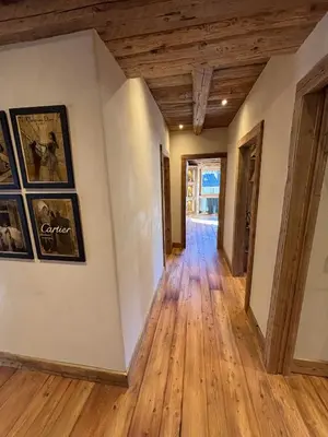 an empty hallway with wood floors and paintings on the walls at Luxury Central Apartment Cortina D'Ampezzo in Cortina dʼAmpezzo