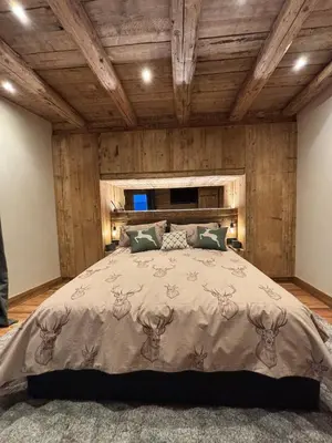a bedroom with a bed with a wooden ceiling at Luxury Central Apartment Cortina D'Ampezzo in Cortina dʼAmpezzo