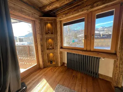 a room with two large windows and a radiator at Luxury Central Apartment Cortina D'Ampezzo in Cortina dʼAmpezzo