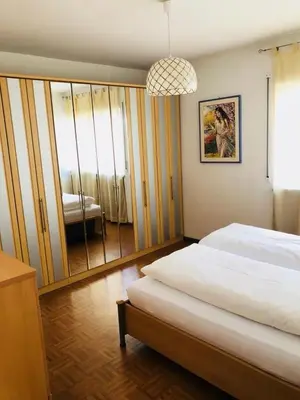 a bedroom with a large bed and a mirror at A&A Apartments Resort in Bressanone