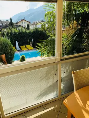 a room with a window with a view of a pool at A&A Apartments Resort in Bressanone
