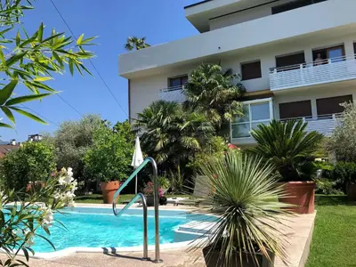 a swimming pool in front of a building at A&A Apartments Resort in Bressanone