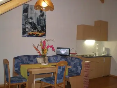 a kitchen with a table and chairs and a kitchen with a laptop at FeWo 3 am Martinshof in Eppan im Süden Südtirols in Missiano