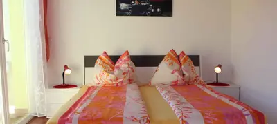 a bedroom with two beds with pillows and two lamps at FeWo 2 am Martinshof in Eppan im Süden Südtirols in Missiano