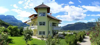 a yellow house with a tower on top of it at FeWo 2 am Martinshof in Eppan im Süden Südtirols in Missiano