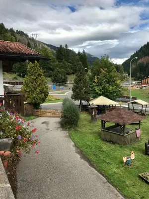 a view of a park with a picnic table and a road at Appartamento nelle Dolomiti 900 mt dallo stadio del salto in Predazzo