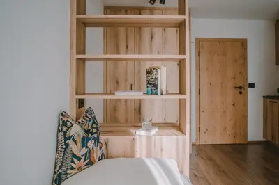 a room with a wooden book shelf and a couch at Luisashaus in Tirolo