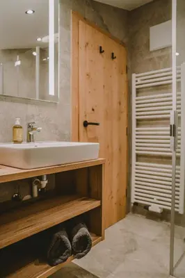 a bathroom with a white sink and a shower at Luisashaus in Tirolo