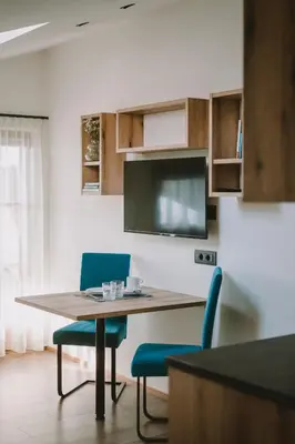 a kitchen with a table and two blue chairs at Luisashaus in Tirolo