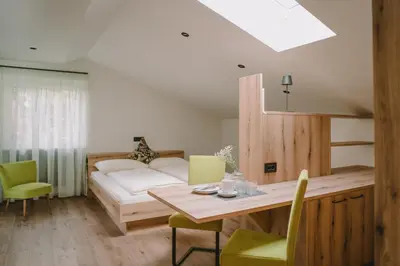 a room with a bed and a table and chairs at Luisashaus in Tirolo