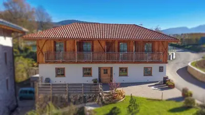 a large house with a balcony on top of it at Mas di Siti in Castelfondo