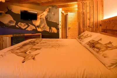 a bedroom with a bed with a deer mural on the wall at Mas di Siti in Castelfondo
