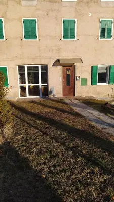 a building with green shuttered windows and a door at Apartment Rosanna Val di Non, Sanzeno in Sanzeno