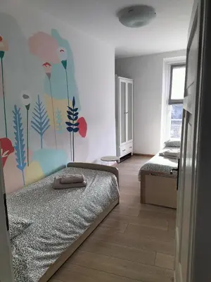 a bedroom with a bed with a flower mural on the wall at Apartment Rosanna Val di Non, Sanzeno in Sanzeno