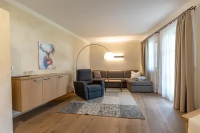a living room with a couch and a chair at Der Unterwirt Guesthouse - Pool & JRE Restaurant in Chiusa
