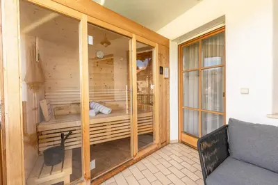 a sauna in a wooden house with a couch at Der Unterwirt Guesthouse - Pool & JRE Restaurant in Chiusa