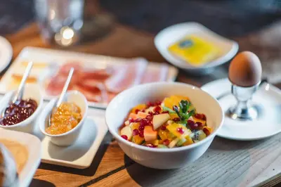 a bowl of food on a wooden table with eggs at Der Unterwirt Guesthouse - Pool & JRE Restaurant in Chiusa