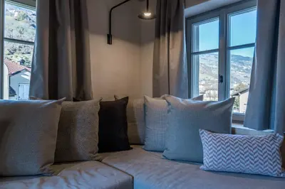 a couch with pillows sitting in front of a window at Ansitz Pontegardena in Ponte Gardena