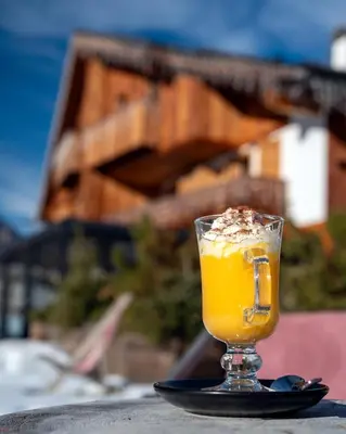a table with a plate of food and glasses of wine at Casa Guargnè in Cortina dʼAmpezzo