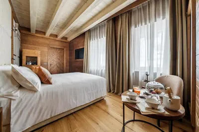 a bedroom with a large white bed and a window at Casa Guargnè in Cortina dʼAmpezzo