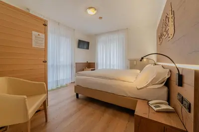 a bedroom with a bed and a desk and a chair at Apartment with Sauna at Pineta Pastry in Sottoguda