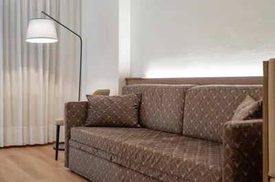 a living room with a couch and a lamp at Apartment with Sauna at Pineta Pastry in Sottoguda