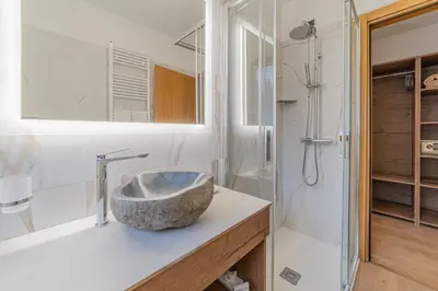 a bathroom with a stone sink and a shower at Apartment with Sauna at Pineta Pastry in Sottoguda