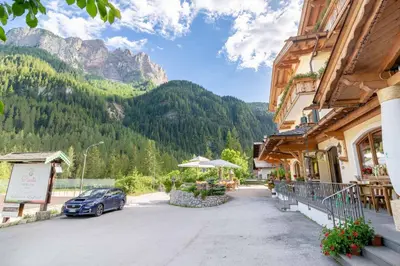 a car parked in front of a building with a mountain at Apartment with Sauna at Pineta Pastry in Sottoguda