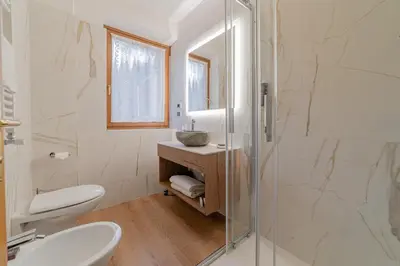 a bathroom with a toilet and a sink and a mirror at Apartment with Sauna at Pineta Pastry in Sottoguda