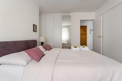 a large white bed with two pillows on it at Heart Apartment in Merano