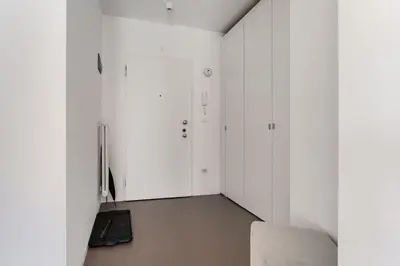 a room with white cabinets and a chair in it at Heart Apartment in Merano