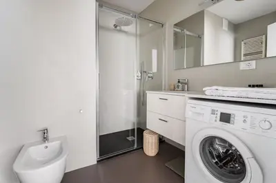 a bathroom with a washing machine and a shower at Heart Apartment in Merano