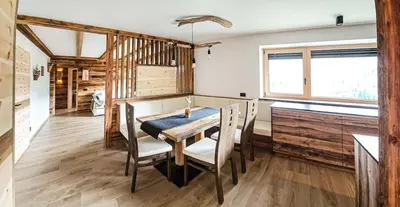 a dining room with a wooden table and chairs at Ciasa Sotiac in Antermoia