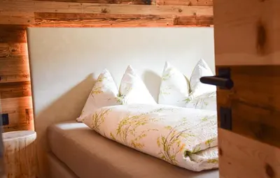 a couch with pillows on it in a room at Ciasa Sotiac in Antermoia