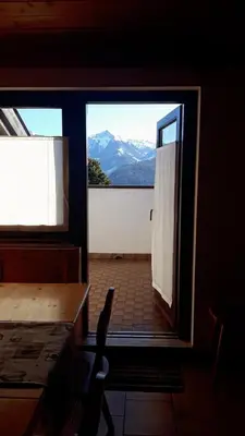 a door to a room with a view of a mountain at Mansarda Villaggio Veronza in Carano