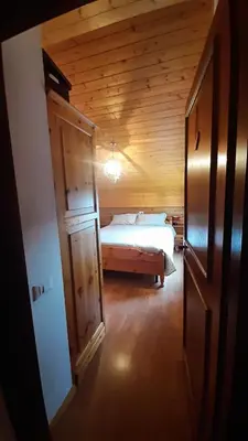 a bedroom with a bed in a wooden cabin at Mansarda Villaggio Veronza in Carano