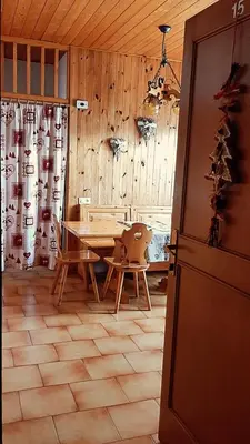 a room with a table and a wooden wall at Mansarda Villaggio Veronza in Carano