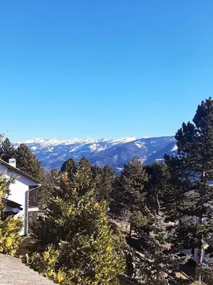a view of the mountains from a hill with trees at Mansarda Villaggio Veronza in Carano