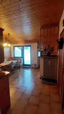 a kitchen and dining room with a table and a room at Mansarda Villaggio Veronza in Carano