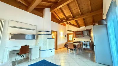 a kitchen with a refrigerator and a table with chairs at Appartamento Villa Nicole in Transacqua