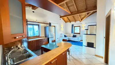 a kitchen with a counter top and a living room at Appartamento Villa Nicole in Transacqua