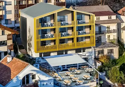 an overhead view of a yellow building with tables and chairs at Alea Living in Tirolo