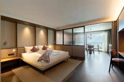 a bedroom with a large bed and a dining room at Alea Living in Tirolo